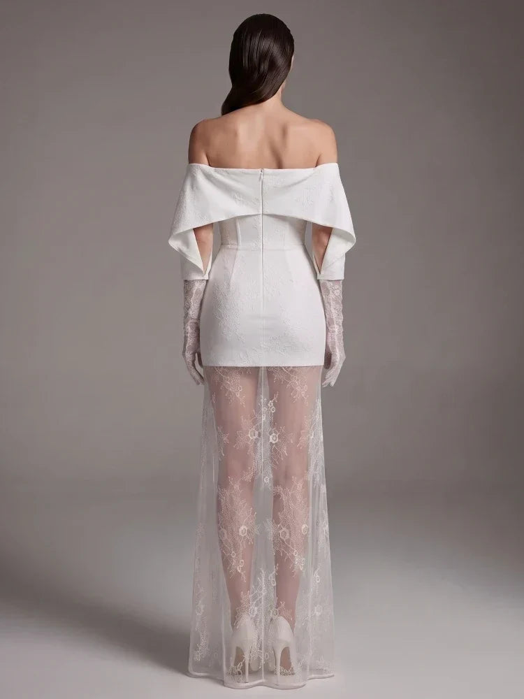 Vestido Nobreza branco marfim em jacquard, com decote ombro a ombro, sobressaia comprida em renda floral e luvas a condizer.