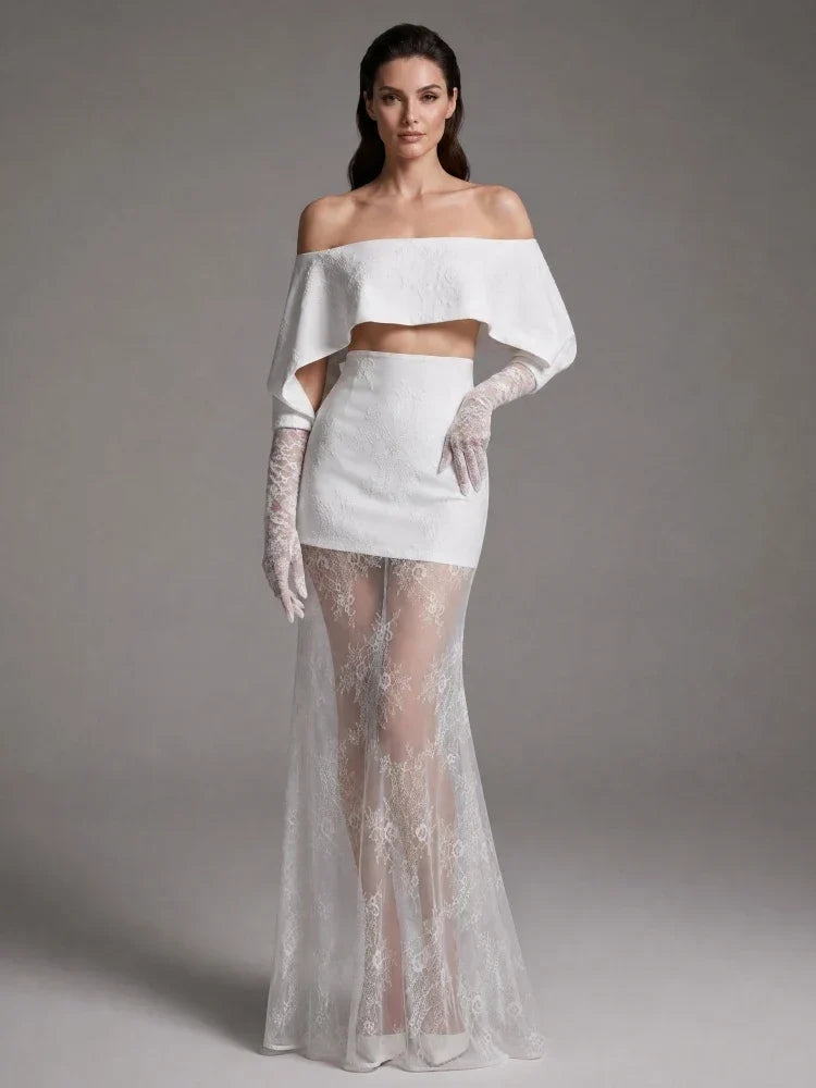 Vestido Nobreza branco em tecido texturado, com decote ombro a ombro, saia curta e sobressaia longa em renda floral