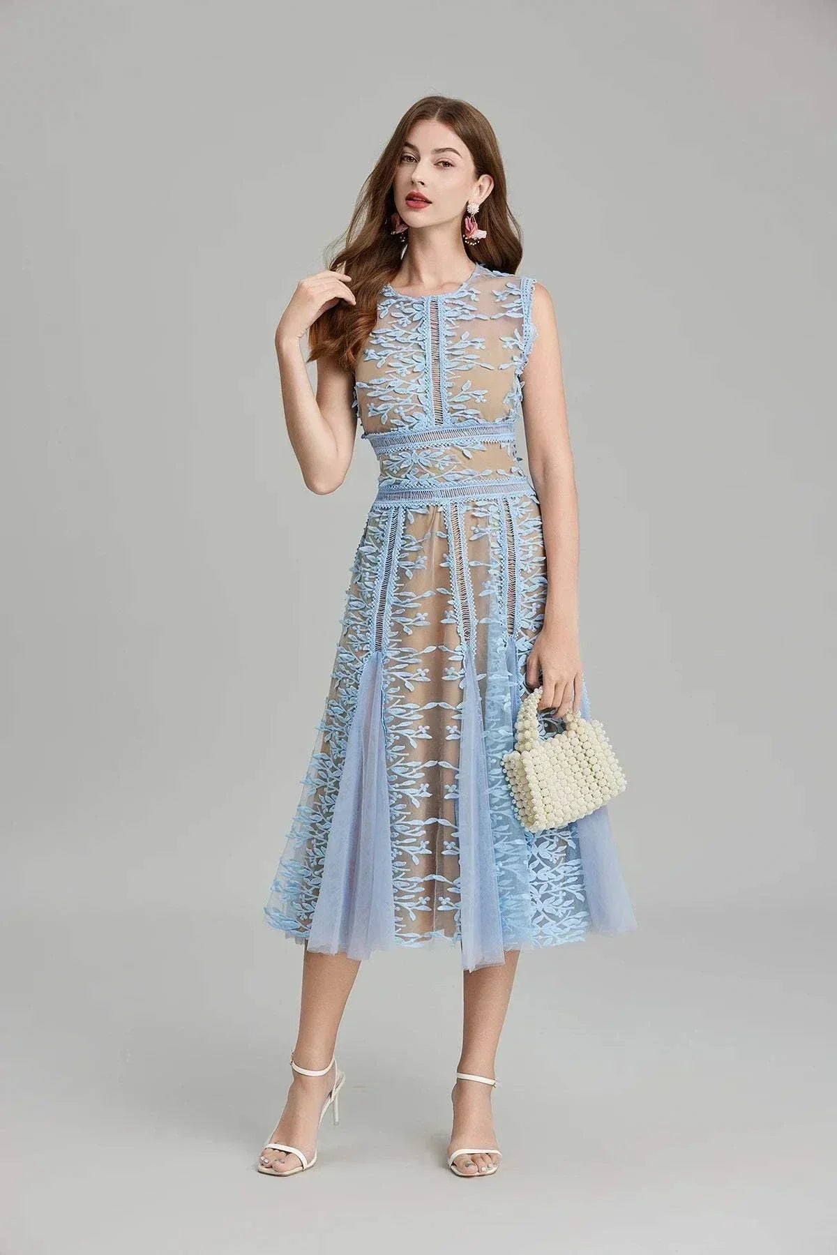 Vestido de festa de verão em malha com bordados florais e fecho dourado, estilo midi sem mangas e decote redondo.