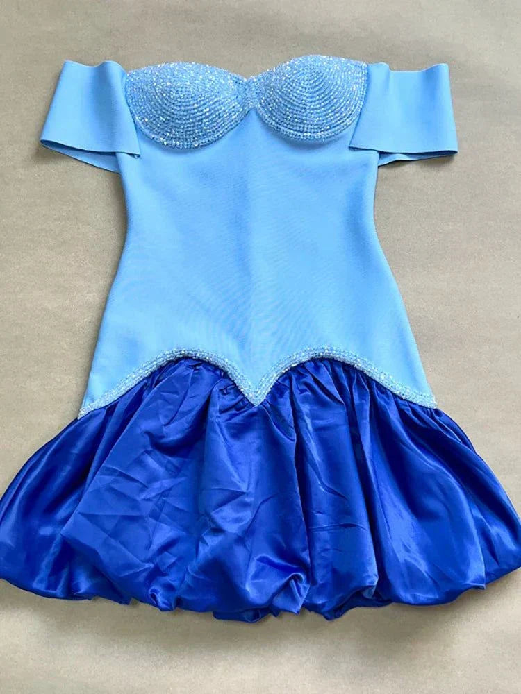 Vestido mini de bandagem vermelho e rosa com ombros descobertos e pedraria elegante.