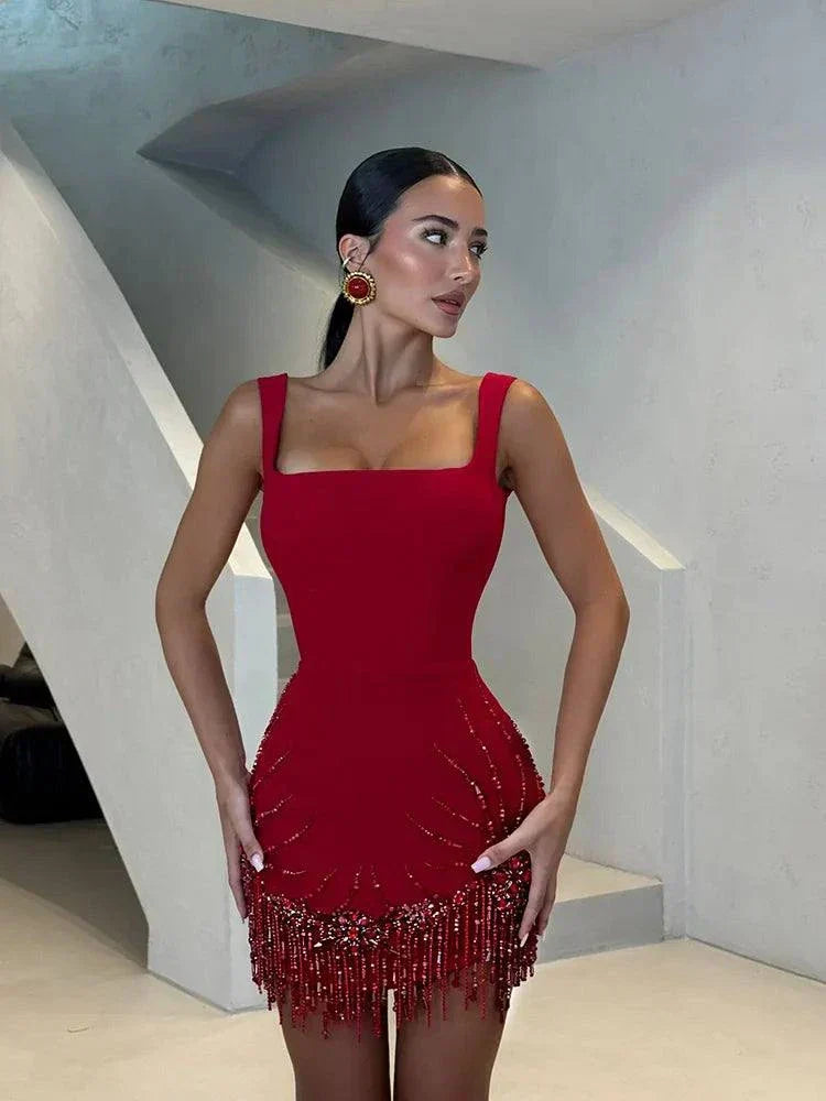 Vestido bodycon vermelho com alças spaghetti, franjas e pedrarias, sem mangas e costas descobertas para festa.