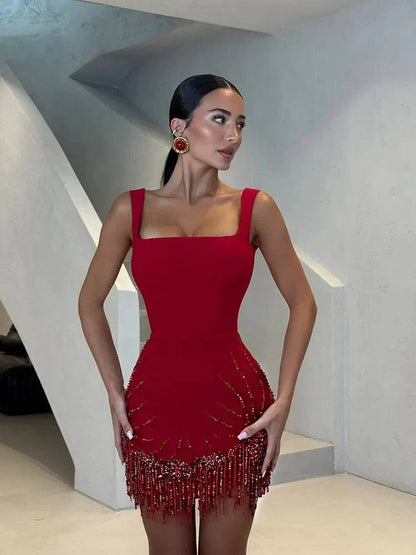 Vestido bodycon vermelho com alças spaghetti, franjas e pedrarias, sem mangas e costas descobertas para festa.