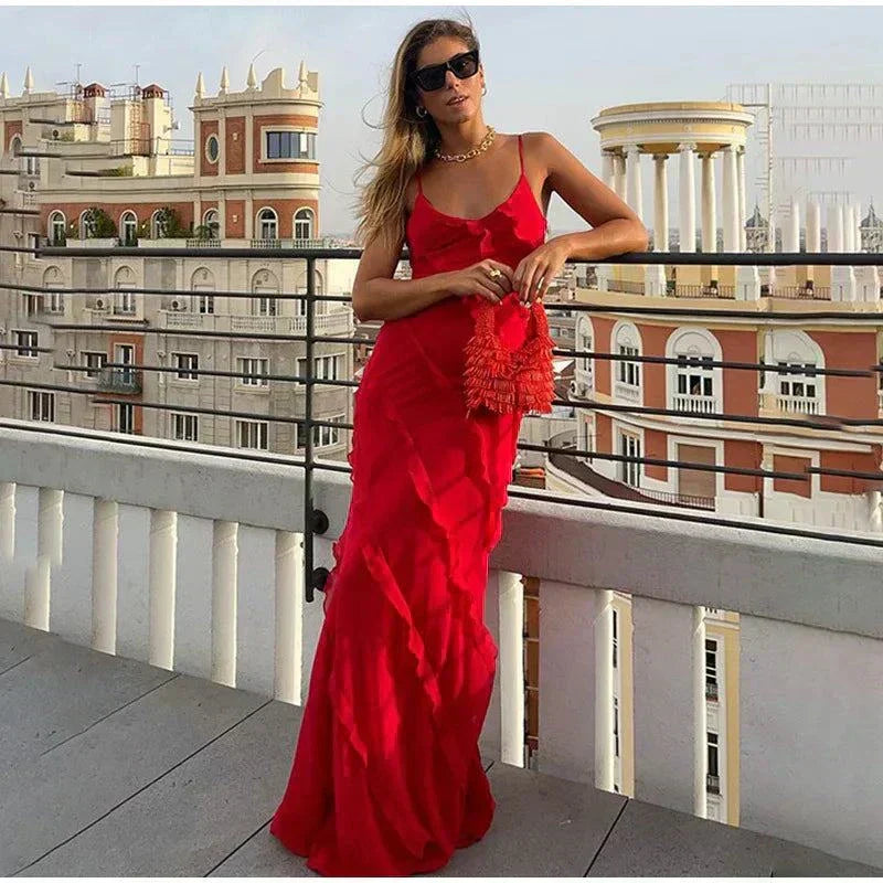 Mulher com vestido longo de alça em chiffon leve e babados em ambiente de verão elegante