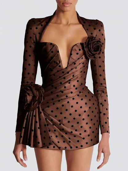 Vestido mini justo com decote em V e dobras, mangas compridas e padrão de bolinhas, ideal para festa e cocktail.
