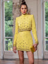 Conjunto Crystal amarelo de top curto com gola alta e mangas compridas, e minissaia com aplicações brilhantes douradas