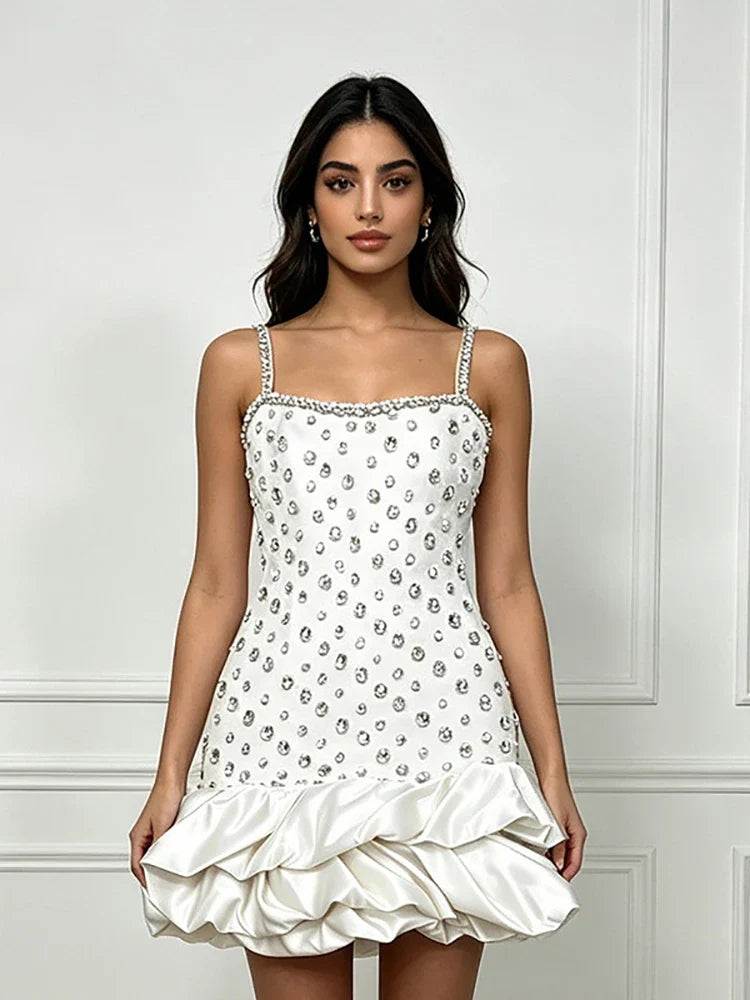 Vestido branco de alças finas, com padrão de cristais prateados e bainha volumosa em cetim com babados