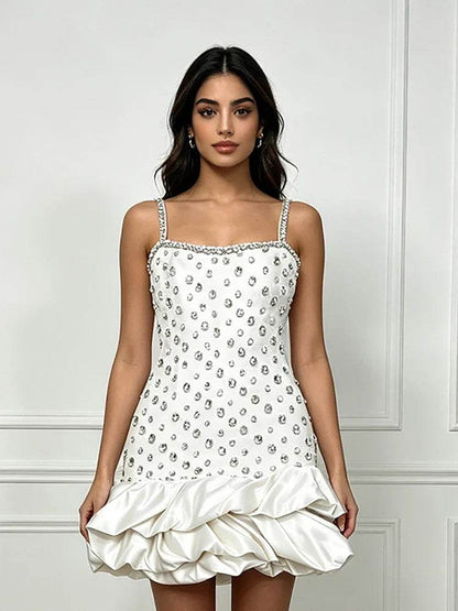Vestido branco de alças finas, com padrão de cristais prateados e bainha volumosa em cetim com babados