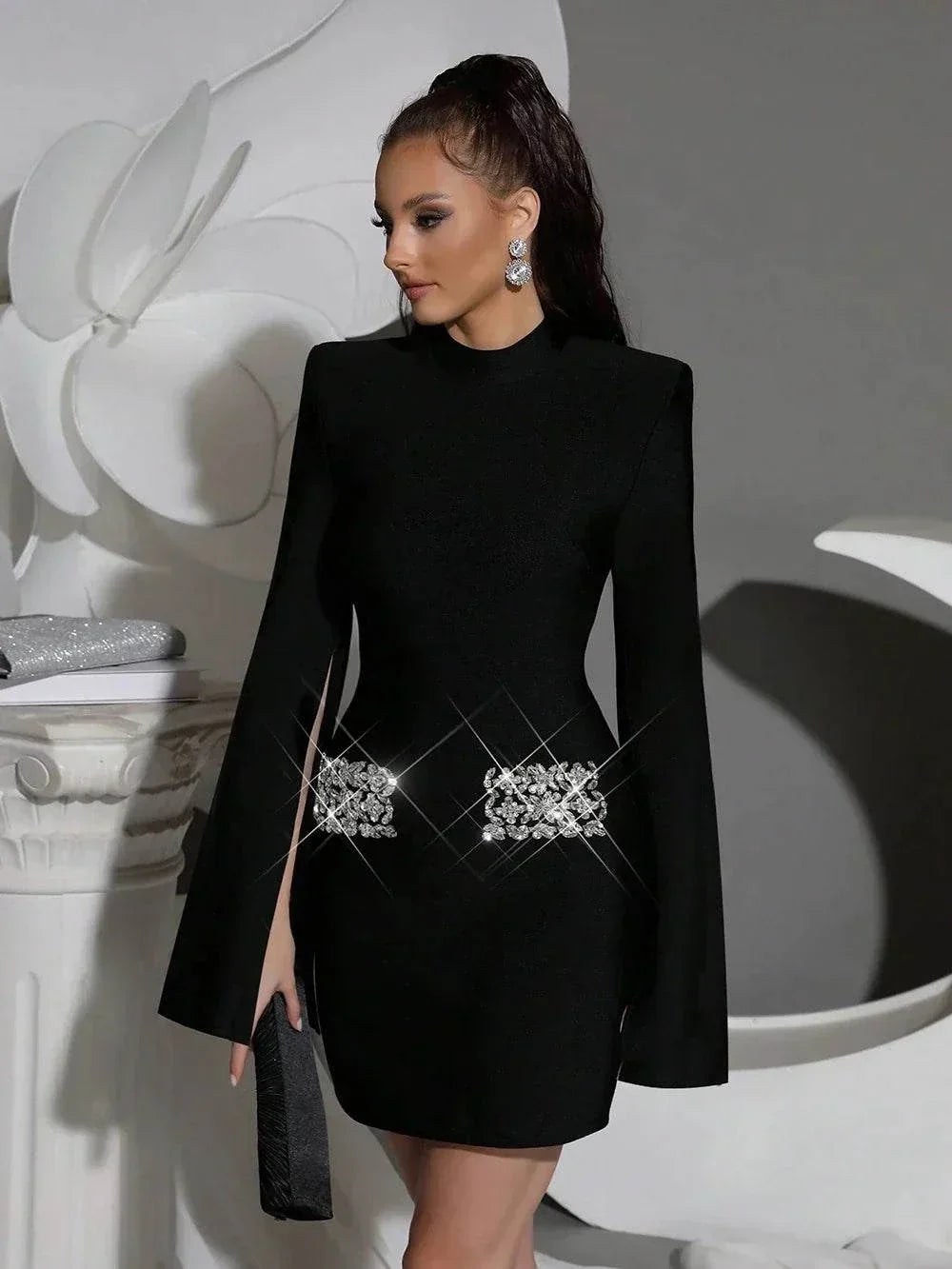 Vestido Mini preto de tecido bandagem com mangas longas estilo capa, gola alta e broches de cristais prateados na cintura