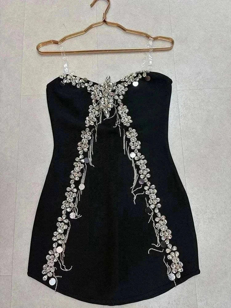 Vestido Mini preto sem alças, em tecido liso, adornado com flores de cristais prateados e correntes brilhantes