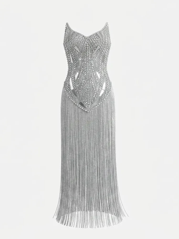 Vestido prateado sem mangas, com corpete estruturado de pedraria geométrica e saia comprida de franjas brilhantes.