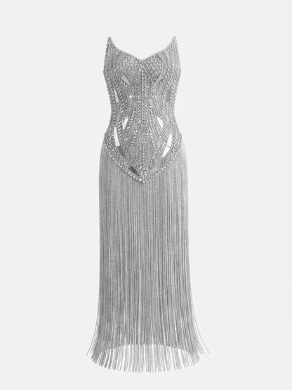 Vestido prateado sem mangas, com corpete estruturado de pedraria geométrica e saia comprida de franjas brilhantes.