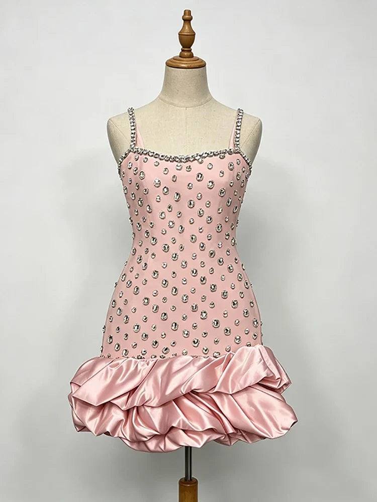 Vestido rosa-claro de cetim com alças finas, cristais aplicados no corpete e bainha volumosa de folhos drapeados