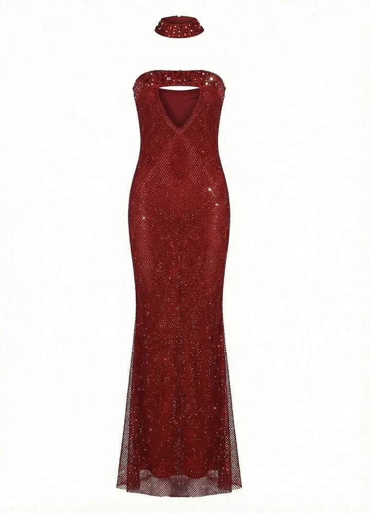 Vestido Rubi comprido vermelho-escuro, coberto de cristais, com decote cai-cai, recorte triangular e corte sereia; inclui gargantilha.